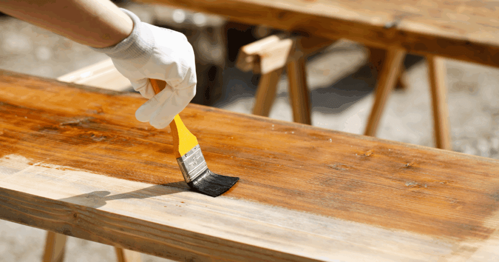 Outdoor wood surface being sealed with a brush before painting