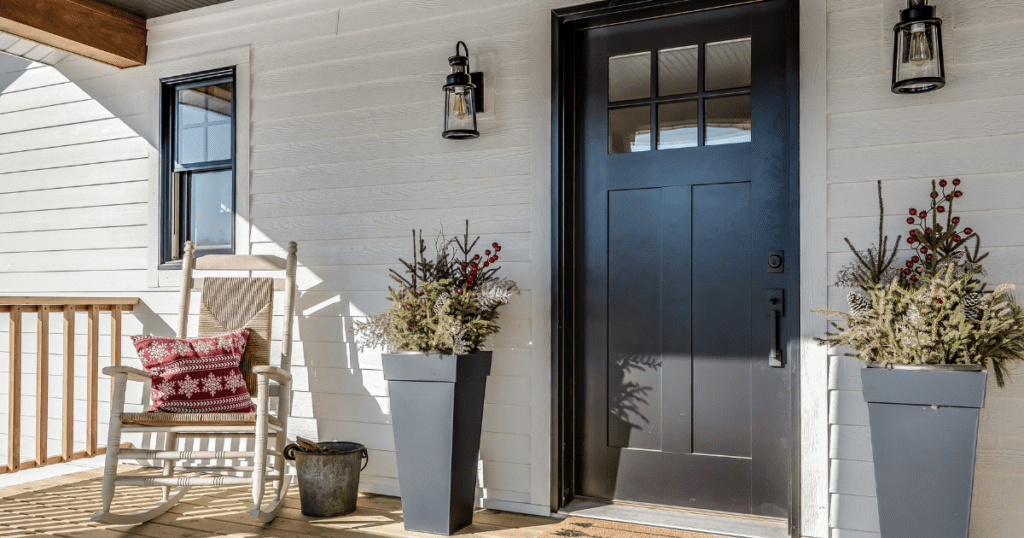 Matte black front door on a white-painted home exterior with modern farmhouse decor.