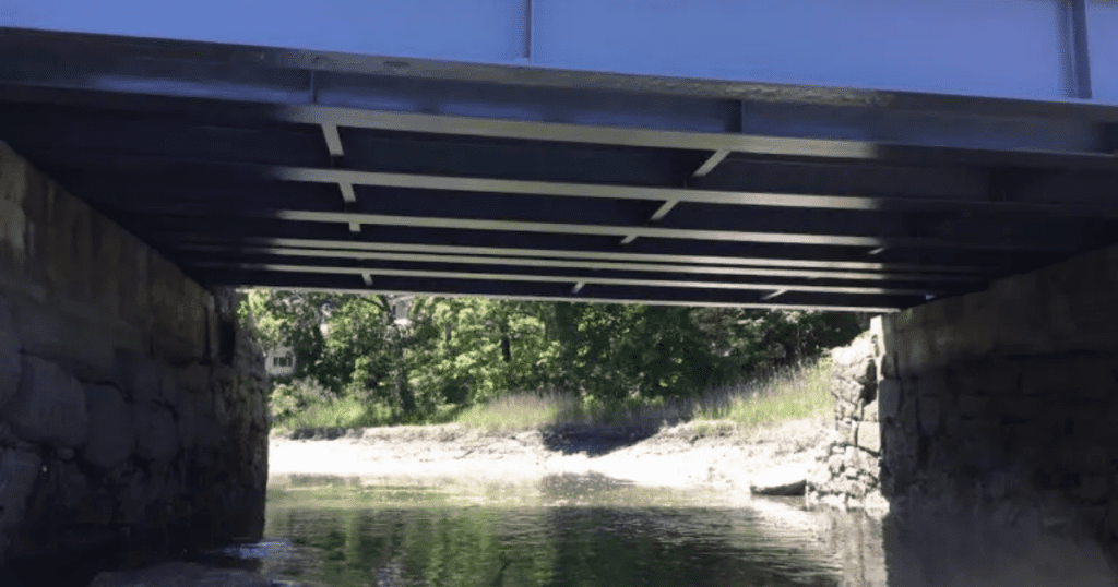 Freshly painted steel beams under a bridge with a smooth, uniform protective coating and clean finish.