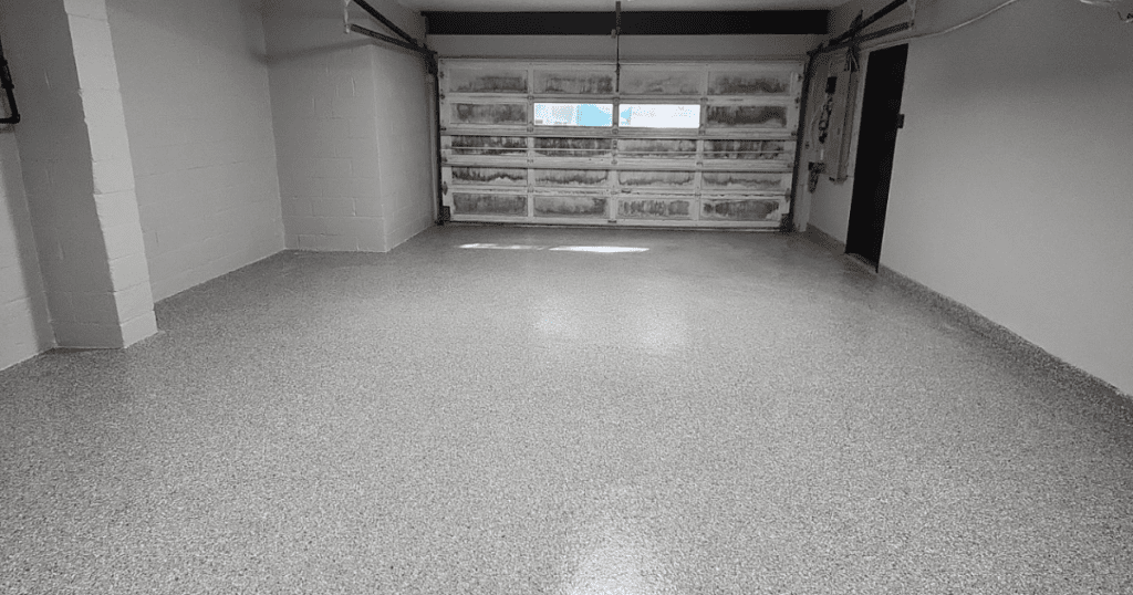 Freshly coated garage floor with a seamless, gray polyurea finish, offering a durable and sleek appearance.