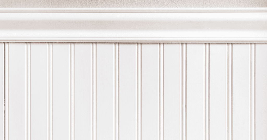 White beadboard paneling with a smooth chair rail, adding a touch of classic charm to a neutral-toned interior.