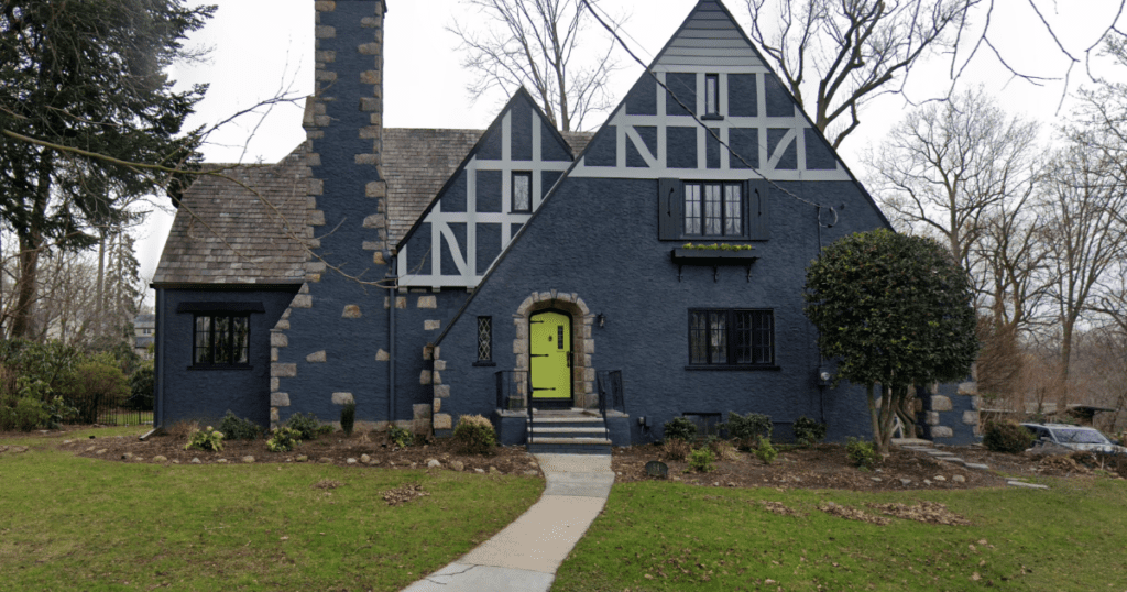 Tudor-style home with dark gray stucco and a bright color door in chartreuse. Excellent example of the effectiveness of painting doors a bright color.