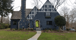 Tudor-style home with dark gray stucco and a bright color door in chartreuse. Excellent example of the effectiveness of painting doors a bright color.