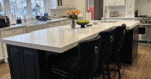Close-up of black kitchen island with white quartz countertop and floral centerpiece.