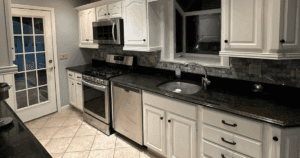 Traditional kitchen with white cabinetry, stainless steel appliances, and a tiled backsplash.