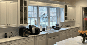 Spacious kitchen with white shaker cabinets and a large bay window over a farmhouse sink.
