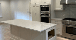 Bright modern kitchen with white cabinetry, stainless steel appliances, and quartz island.