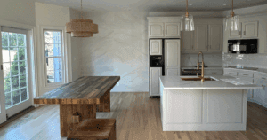 Kitchen and dining area with painted white cabinetry, quartz island, and rustic wood dining table.
