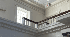 Elegant church interior featuring white walls, molding, and wood handrails.