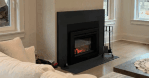 Minimalist black fireplace surround in a modern living room with light walls and wood flooring.