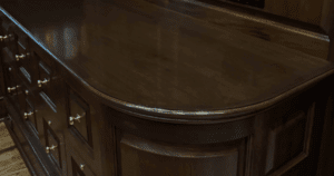 Polished dark wood cabinetry with curved detailing and brass hardware.