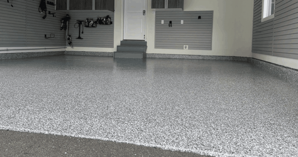 Close-up view of a garage entry with newly applied epoxy flooring and organized wall storage.