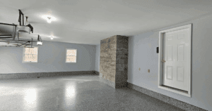 Open garage with freshly coated epoxy flooring and natural stone chimney. This floor solution offers garage floor safety in addition to premium aesthetic.