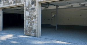 Spacious garage with gray epoxy floors, blue-gray walls, and a center block column.