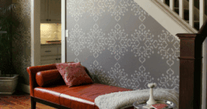 Stairwell nook with grey patterned wallpaper and a leather chaise lounge.