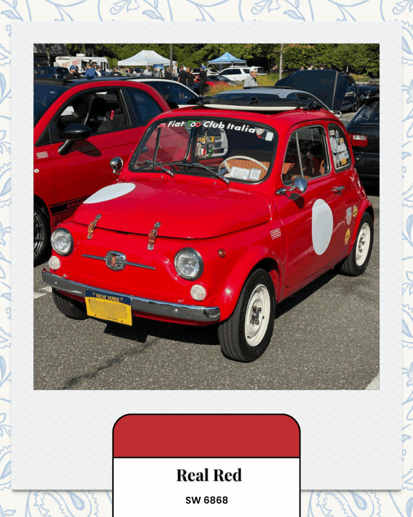 A bright red vintage Fiat 500 with white racing decals, part of the Fiat Club Italia, parked among other classic cars.