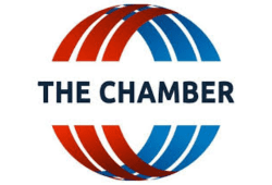 The Chamber logo featuring a circular red and blue striped design with bold text across the center.